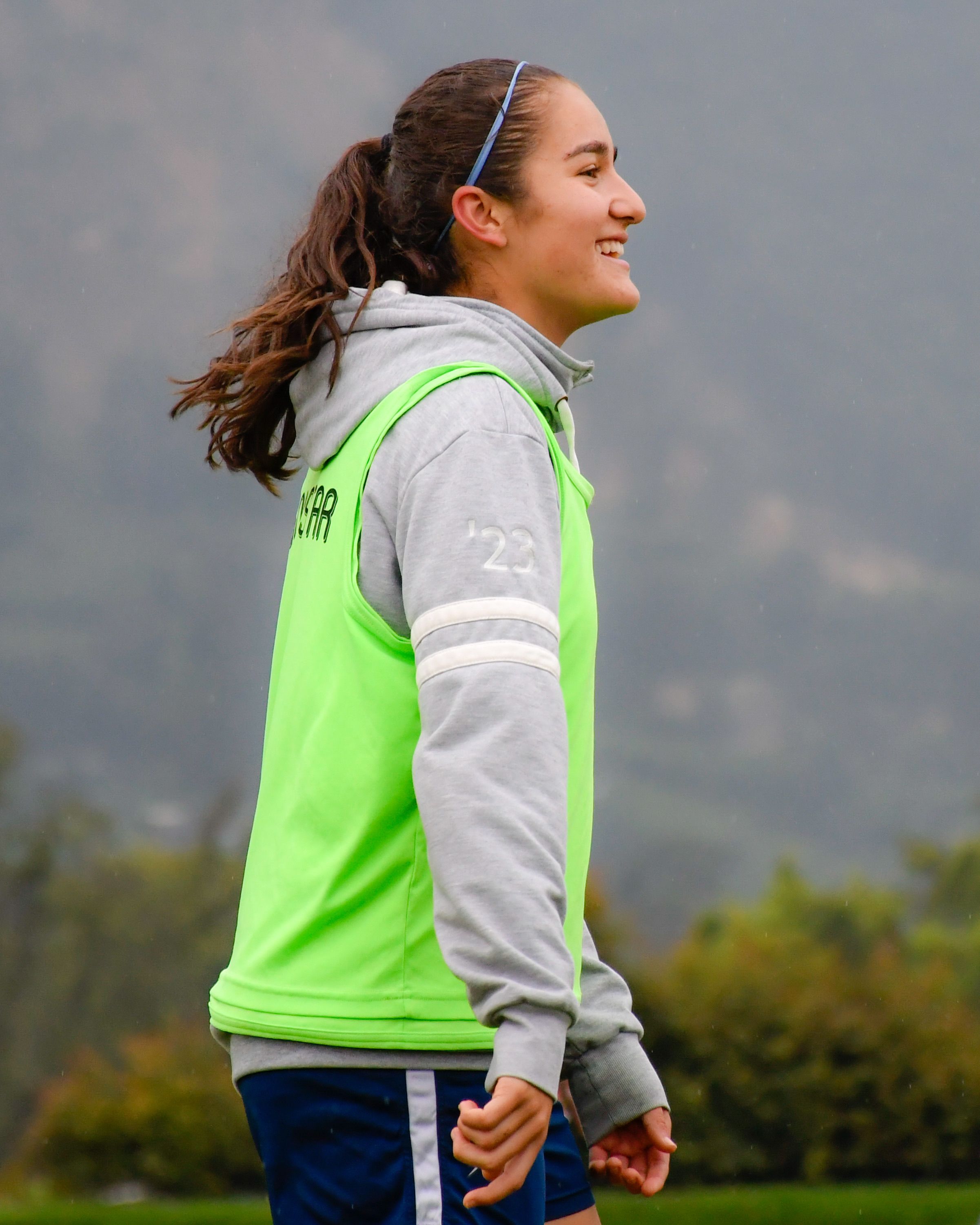 A happy sportswoman in a neon vest enjoys the outdoors, embodying fitness and positivity.