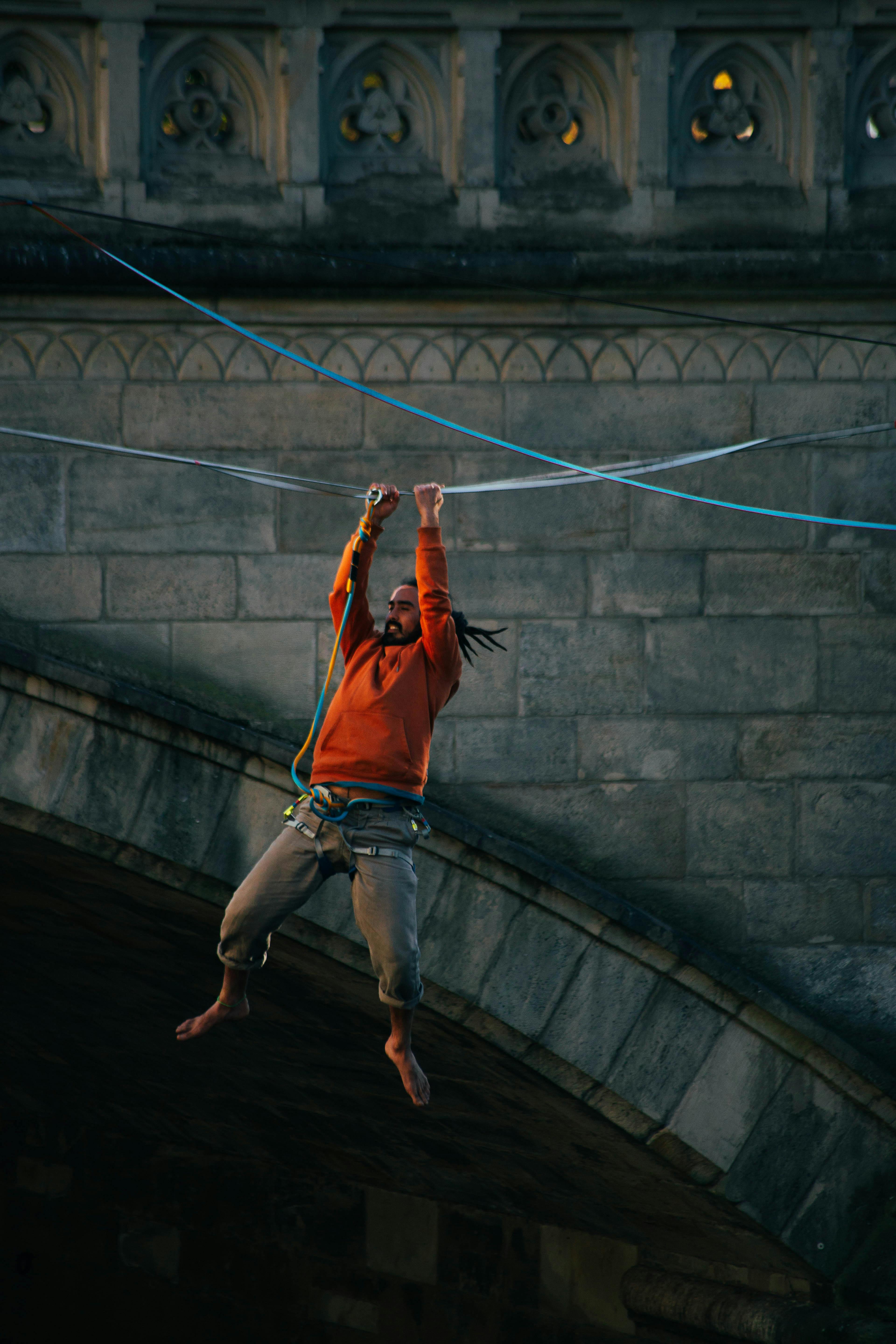 Man Hanging from Rope by Bridge · Free Stock Photo