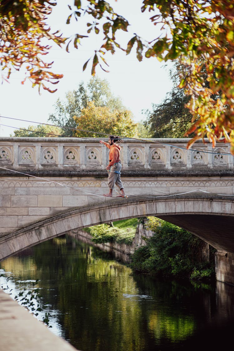 Acrobat On Line Over River Near Bridge