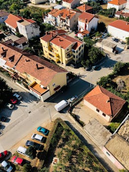 从鸟瞰图可以看到，一个迷人的住宅区里，红顶房屋和停放的汽车错落有致