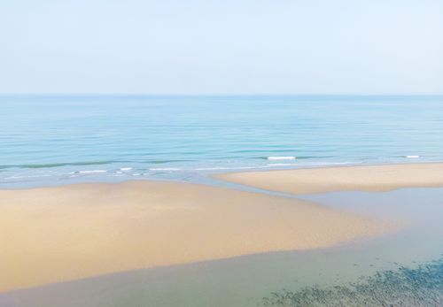 Free A serene beach scene with golden sands and a calm, turquoise sea stretching to the horizon. Stock Photo