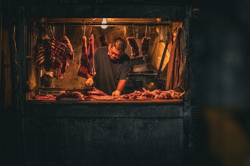 Man Preparing Raw Meat in Market Stall 