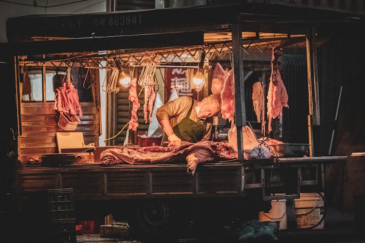 Butcher Cutting Open Pig On Market