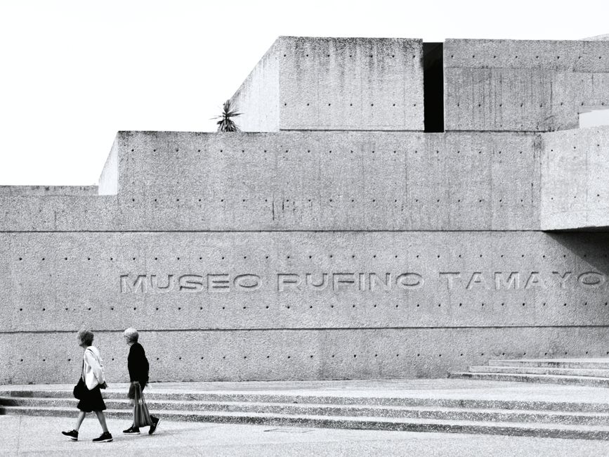 Black and white photo of Museo Rufino Tamayo's concrete facade with pedestrians.