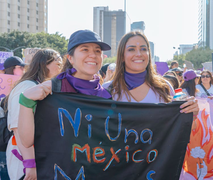 Women Posing With A Black Banner On A Rally