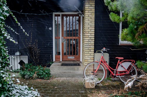 Red Bicycle Parked by the Home Entrance