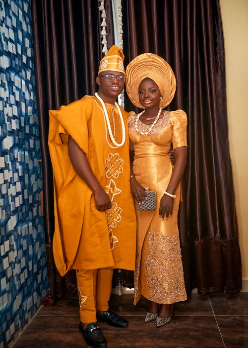 Woman and Man Posing in Orange, Traditional Clothin
