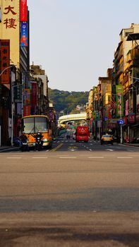 Busy urban street with vehicles and vibrant cityscape, showcasing modern skyscrapers and bustling traffic.