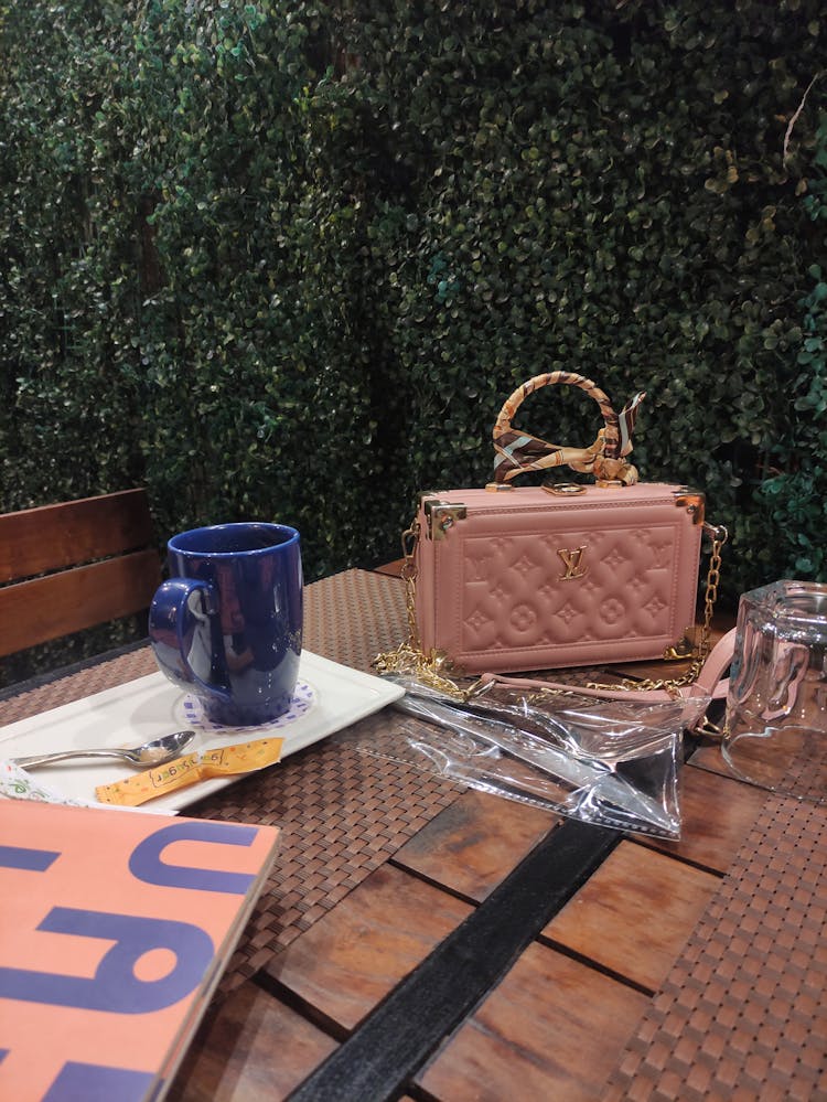 Blue Mag And A Handbag On A Garden Table