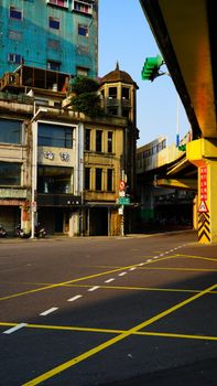 City street view featuring historic architecture and elevated road in bright daylight.
