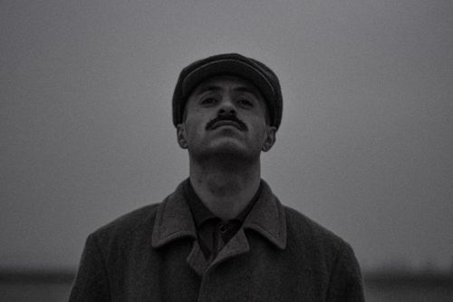 Free Moody black and white portrait of a man wearing a hat, showcasing a vintage style. Stock Photo