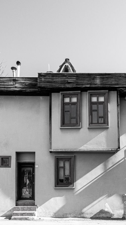Free Elegant facade of a vintage house in black and white tones, showcasing windows and doors. Stock Photo