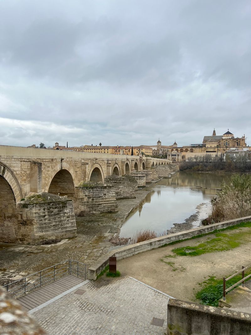 The Roman bridge of Córdoba crossing the Guadalquivir river with the Mezquita in the background