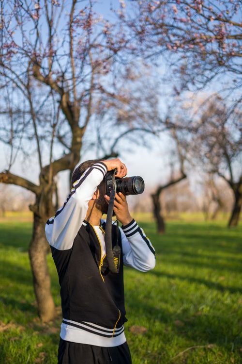 Free Man photographing in a scenic Srinagar park during springtime. Stock Photo