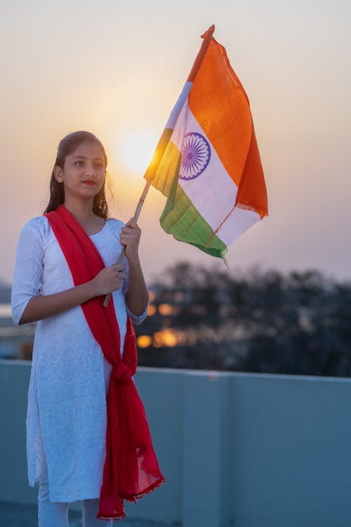 Woman in Traditional Clothing and with Flag of India at Sunset