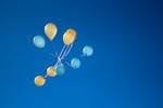 Photo of Yellow And Blue Balloons On Sky