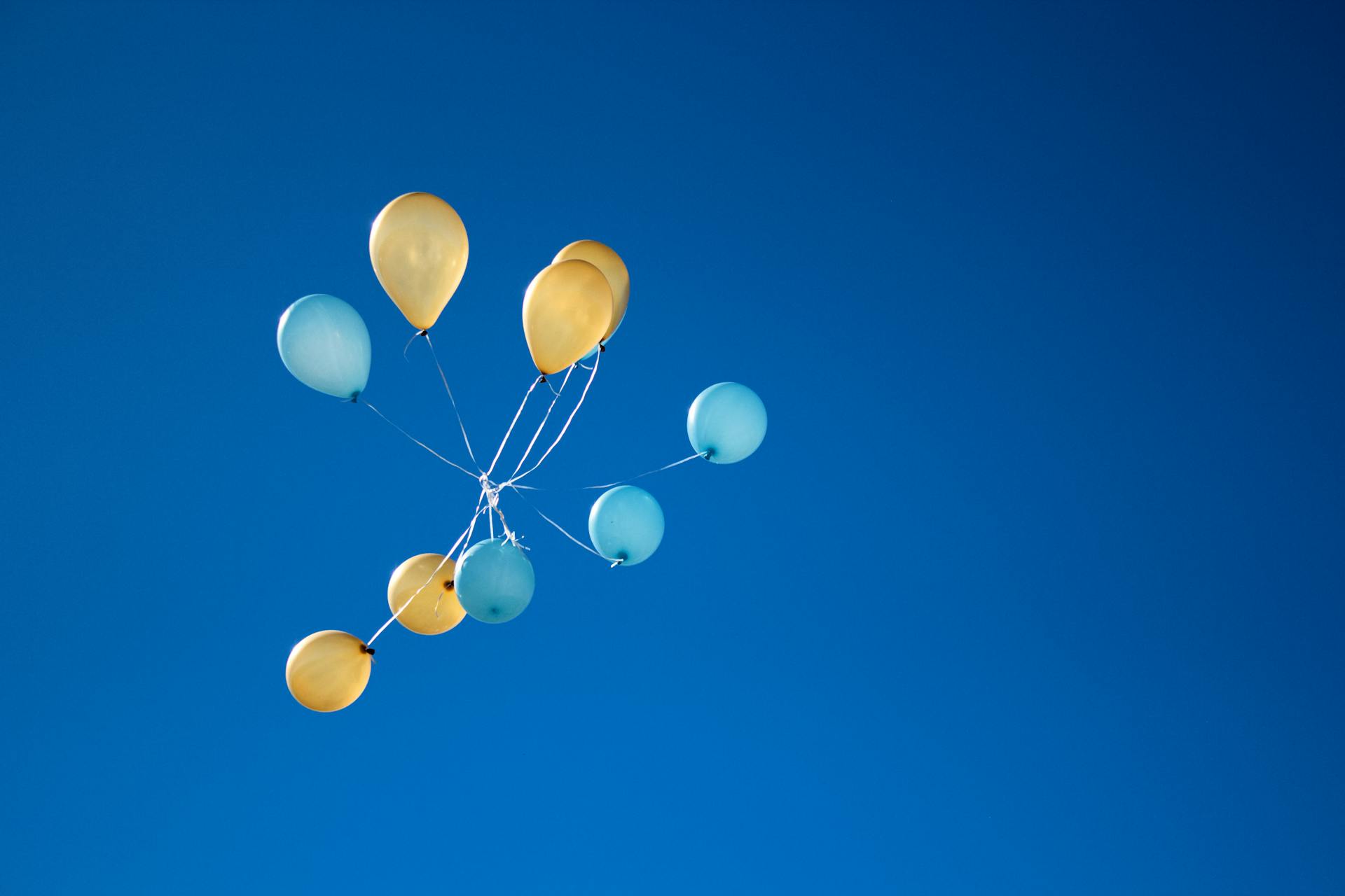 Photo of Yellow And Blue Balloons On Sky