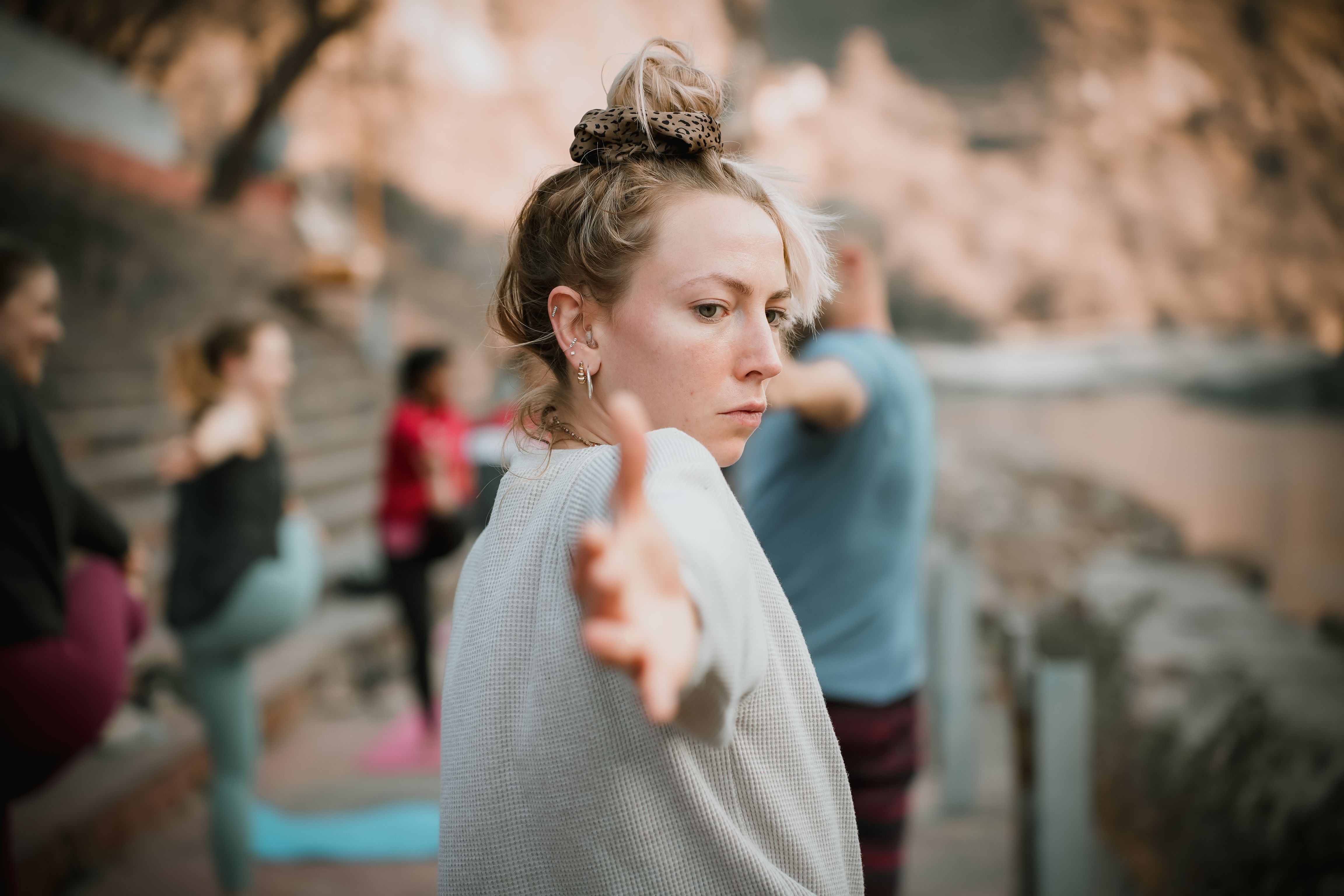 A woman practicing yoga outdoors in Rishikesh amid soft natural greenery, calm and grounded in warm daylight