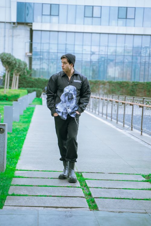 Free Young man walks in Istanbul, showcasing urban fashion against a modern architectural backdrop. Stock Photo