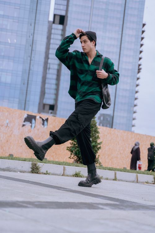Free A stylish man in a green shirt walking confidently on the urban streets of Istanbul. Stock Photo