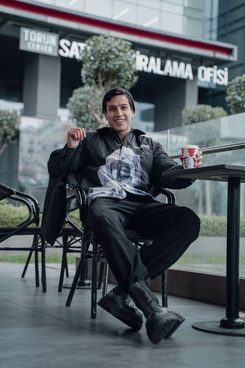 Free A young man enjoying a relaxing moment with a drink at an outdoor café in Istanbul, Turkey. Stock Photo
