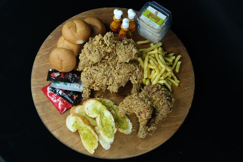 Free A top-down view of a fried chicken platter with buns, fries, and condiments. Stock Photo