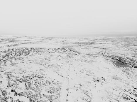 A snowy, serene aerial view showcasing an expansive winter landscape.