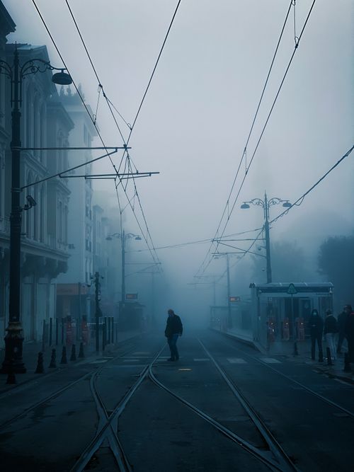 Free Misty morning scene on a street in Istanbul, featuring a lone pedestrian crossing tram tracks. Stock Photo