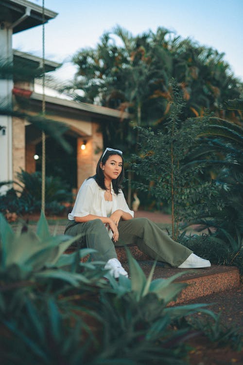 Young Woman in a Trendy Outfit Sitting on Steps 