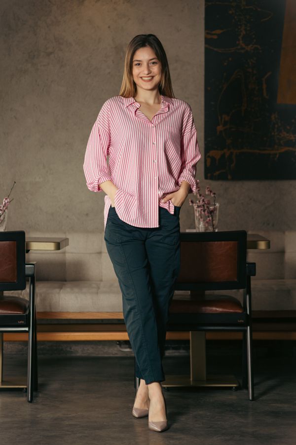 Woman in a silk blouse and high-waisted trousers