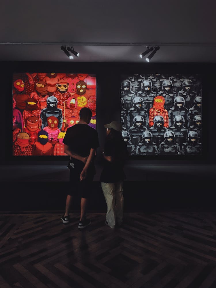 Young Man And Woman Looking At Art In The Gallery