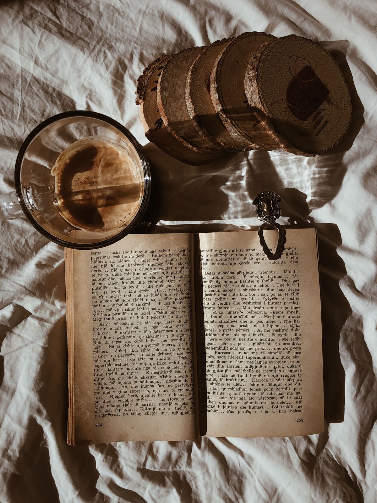 Wood slice craft ideas with a stack of wood slice coasters with bark edges beside a coffee cup