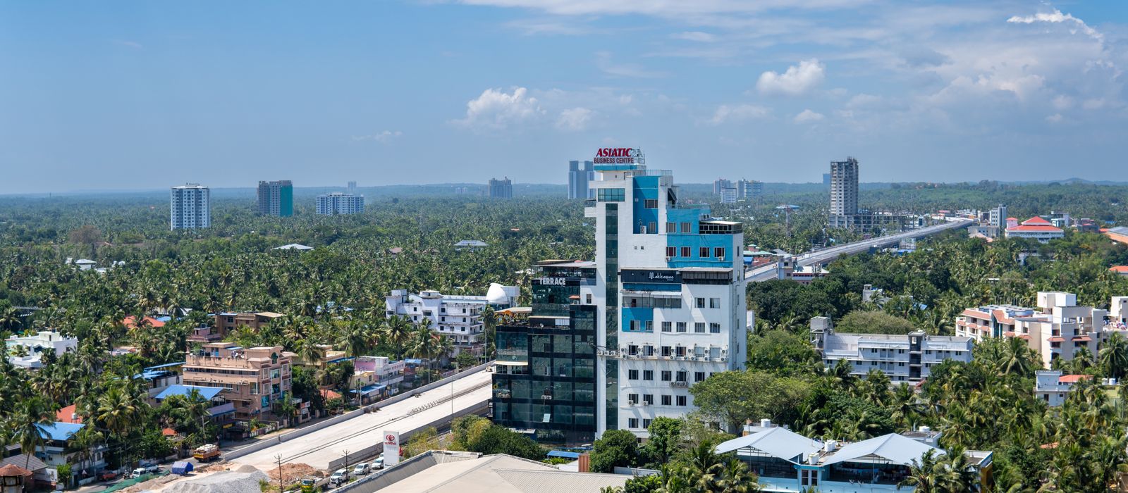 Panoramic aerial view of Thiruvananthapuram cityscape with lush greenery and modern architecture. — flights from New Delhi to Thiruvananthapuram