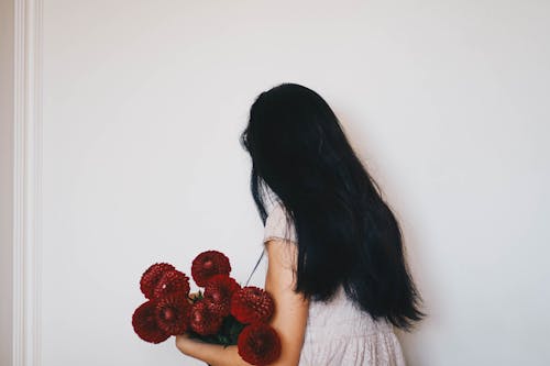 Woman Holding Bouquet of Red Dahlia Flowers