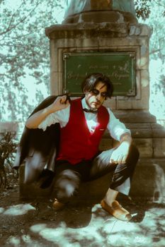 Photo by Gerardo Manzano Fashionable man posing by a historic monument in Mexico City park, showcasing style and elegance.