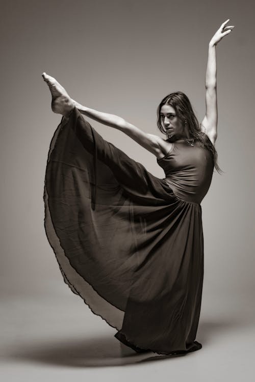 Dancer in a Long Dress Holding Her Leg Up 