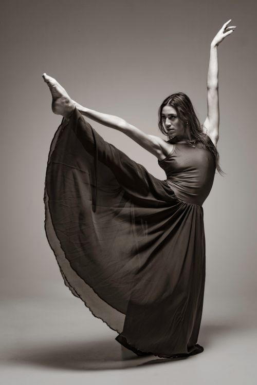 Free Ballerina performing dynamic pose with flowing dress in studio setting, showcasing elegance and movement. Stock Photo
