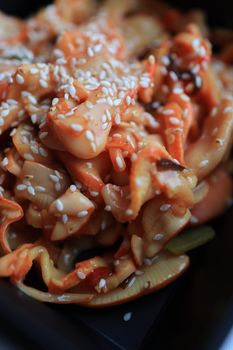 Close-up of a flavorful octopus dish garnished with sesame seeds, showcasing texture and culinary detail.