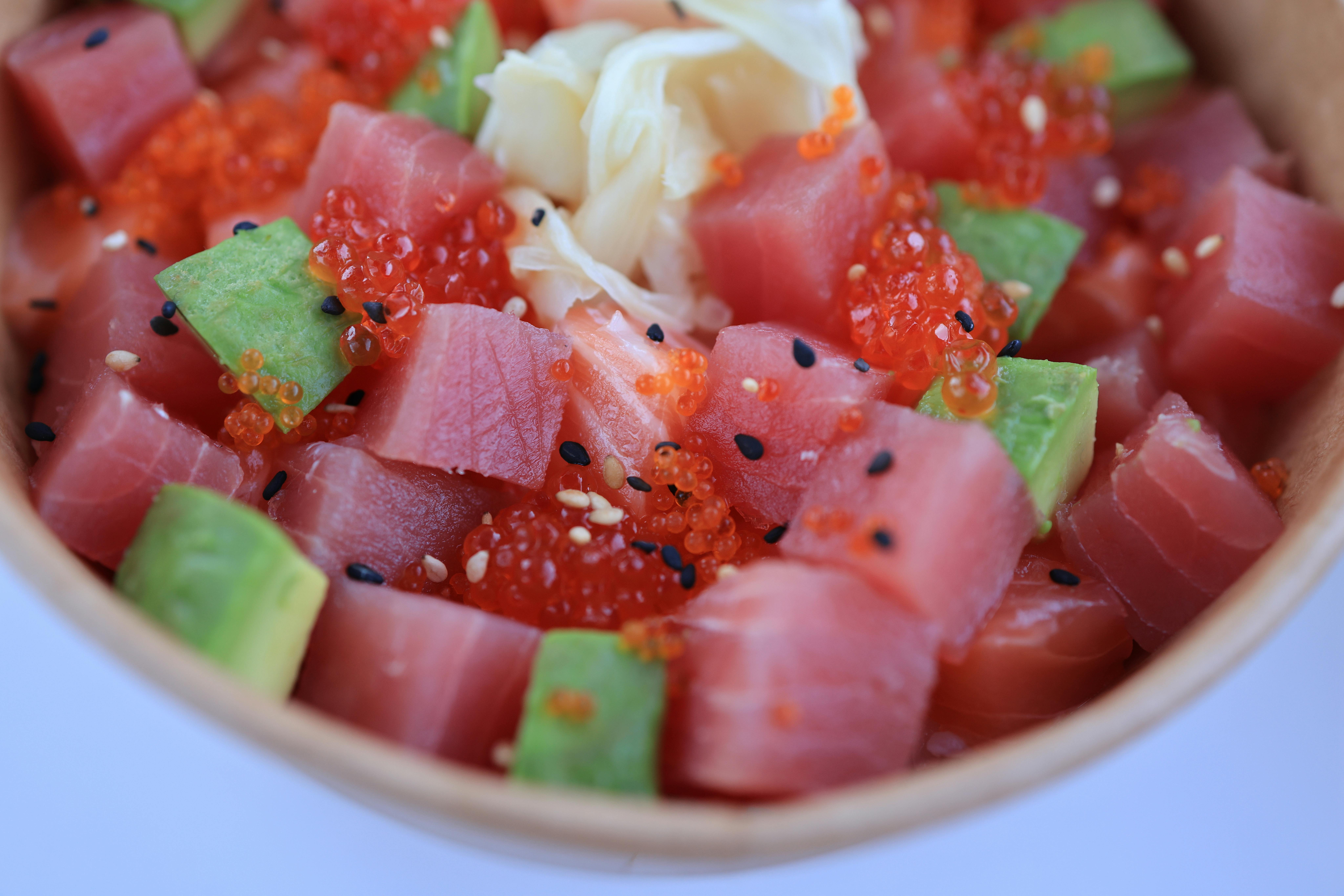 Delicious poke bowl with tuna, avocado, caviar, and sesame seeds. Perfect for healthy eating lovers.