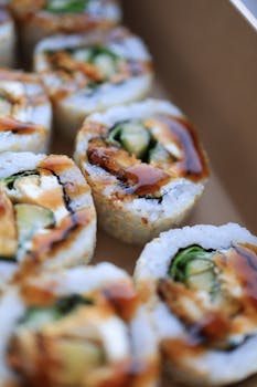 Mouth-watering sushi rolls with fresh ingredients and savory sauce, perfect for Asian cuisine lovers.