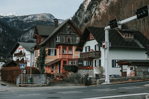 Picturesque village houses with a mountainous backdrop in Austria, capturing serene winter vibes.