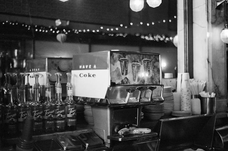 A Vintage Soda Machine And A Bunch Of Syrups On The Counter In A Diner 