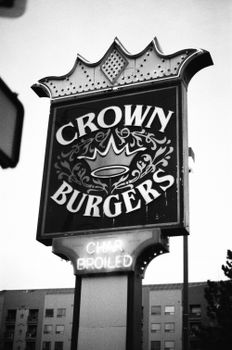 Classic Crown Burgers neon sign captured in urban setting.
