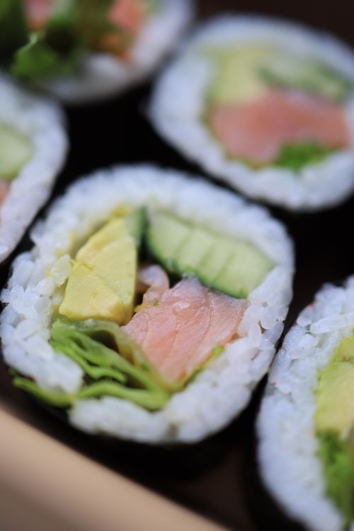 Free Close-up of fresh salmon and avocado sushi rolls, emphasizing crisp ingredients and vibrant colors. Stock Photo