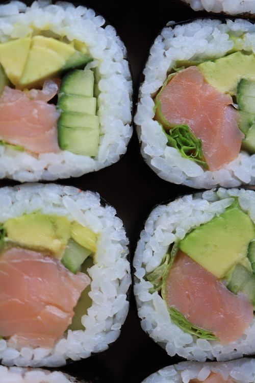 Free Fresh salmon and avocado sushi rolls in close-up view, showcasing vibrant colors and textures. Stock Photo