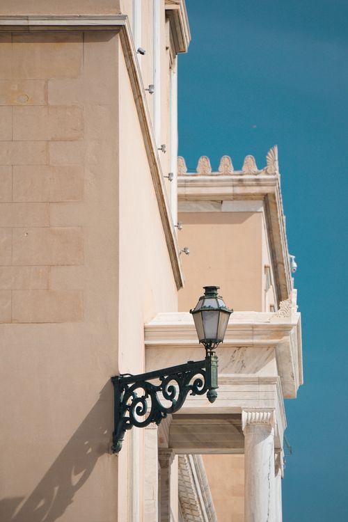 Free Stylish facade with ornate lamp and classic architectural details under a clear blue sky. Stock Photo