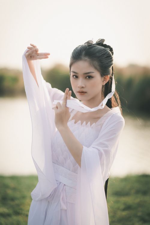 Free Beautiful woman in traditional attire posing gracefully by the lakeshore. Stock Photo