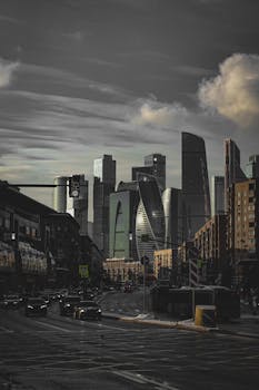 Dramatic urban skyline featuring modern skyscrapers under cloudy skies, showcasing futuristic architecture.