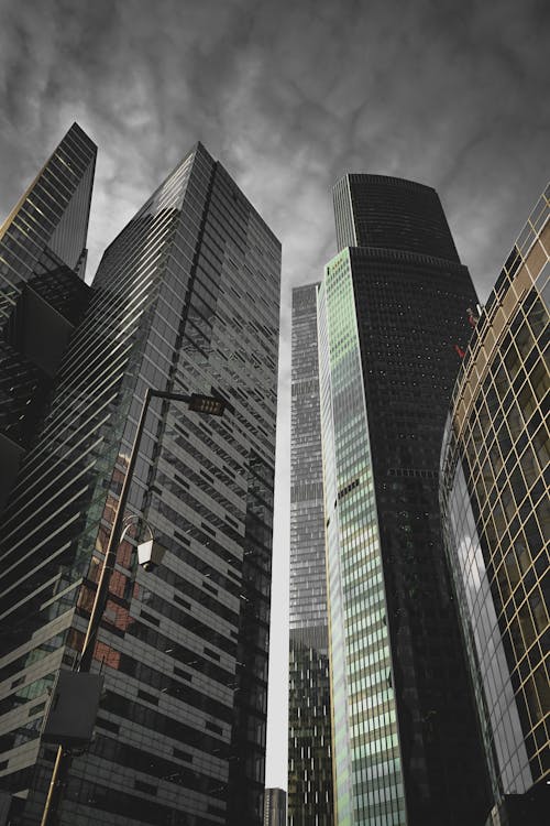 Low Angle Shot of Glass Skyscrapers against Grey Clouded Sky