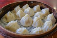 Freshly steamed xinolongbao dumplings in a bamboo steamer, showcasing traditional Chinese cuisine.